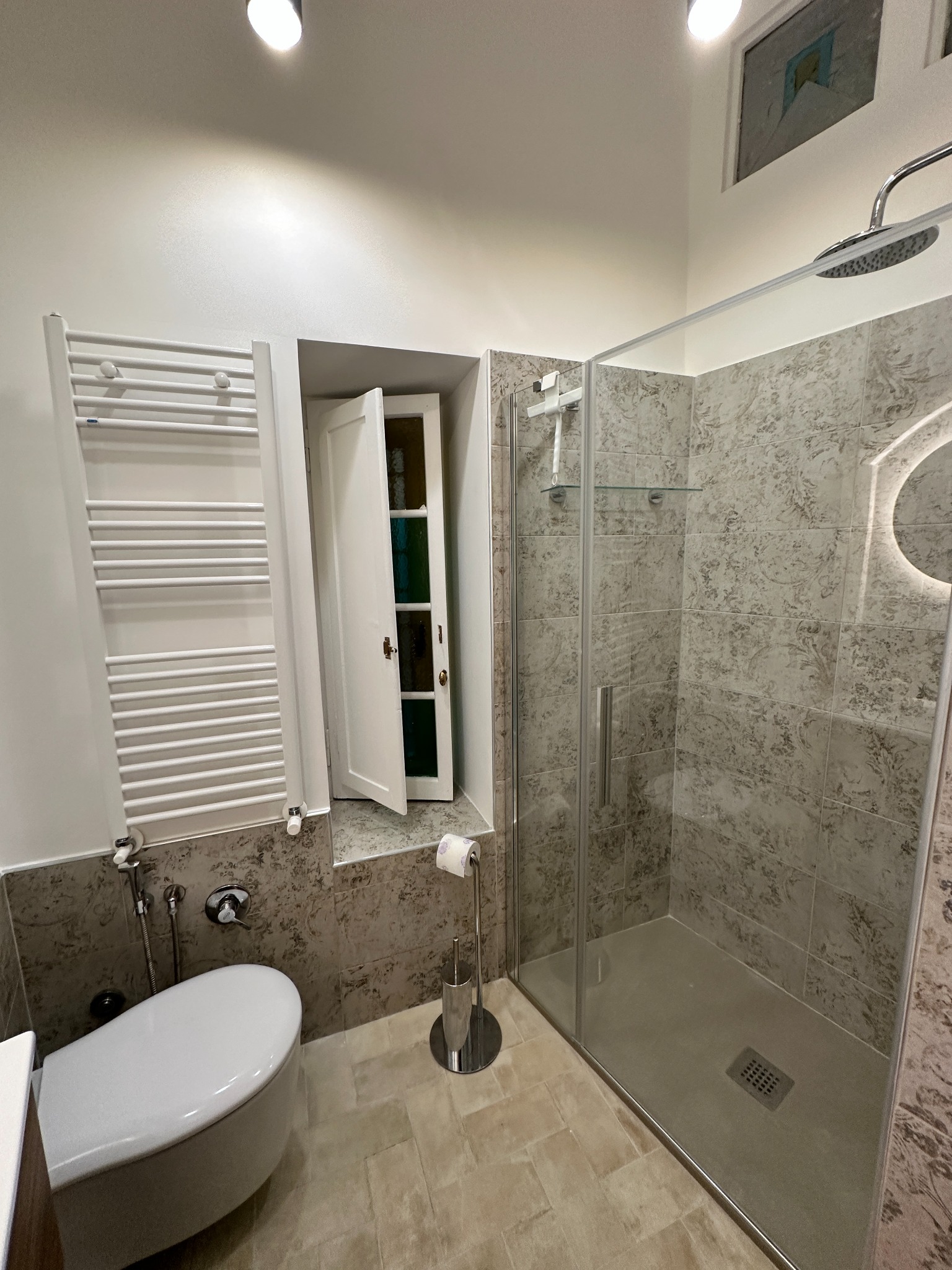 Bathroom with glass shower cabin and heated towel rail