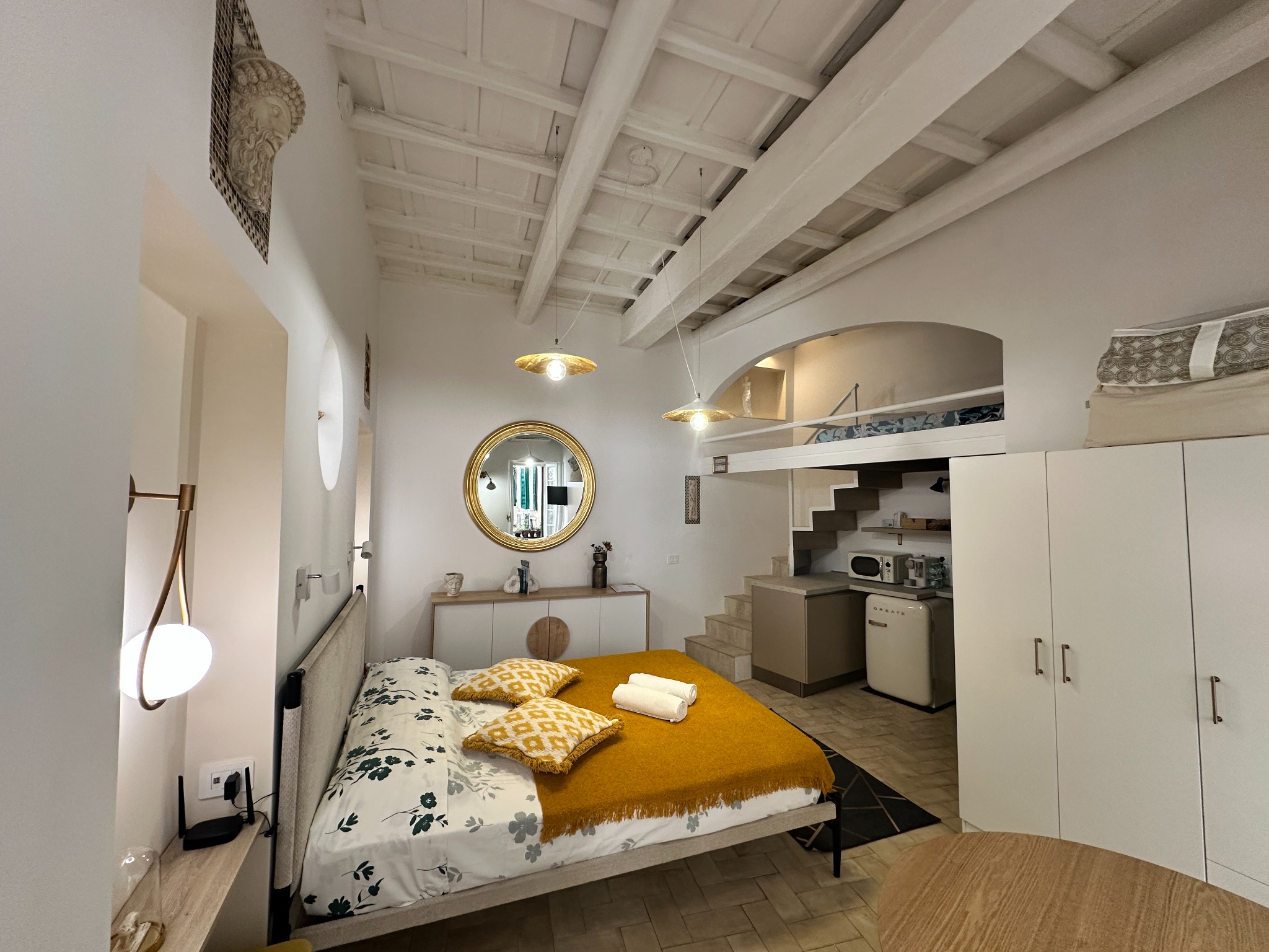 Cortile Decorus interior with double bed, dining area and mezzanine